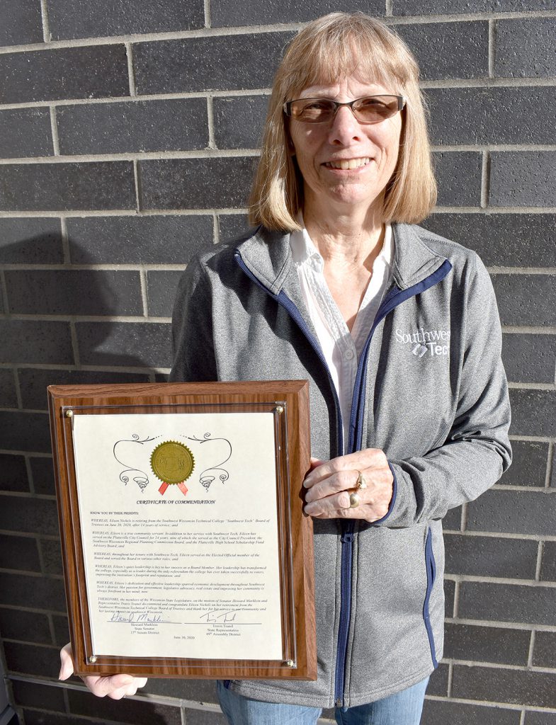 Woman standing holding plaque