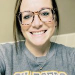 Woman with glasses, grey shirt, headshot