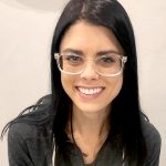 Female with long black hair and clear glasses, headshot.