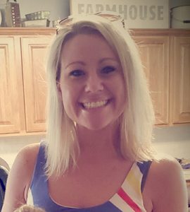 Woman with blonde hair and multi-colored tank top, headshot.