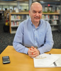 Man at library desk looking forward