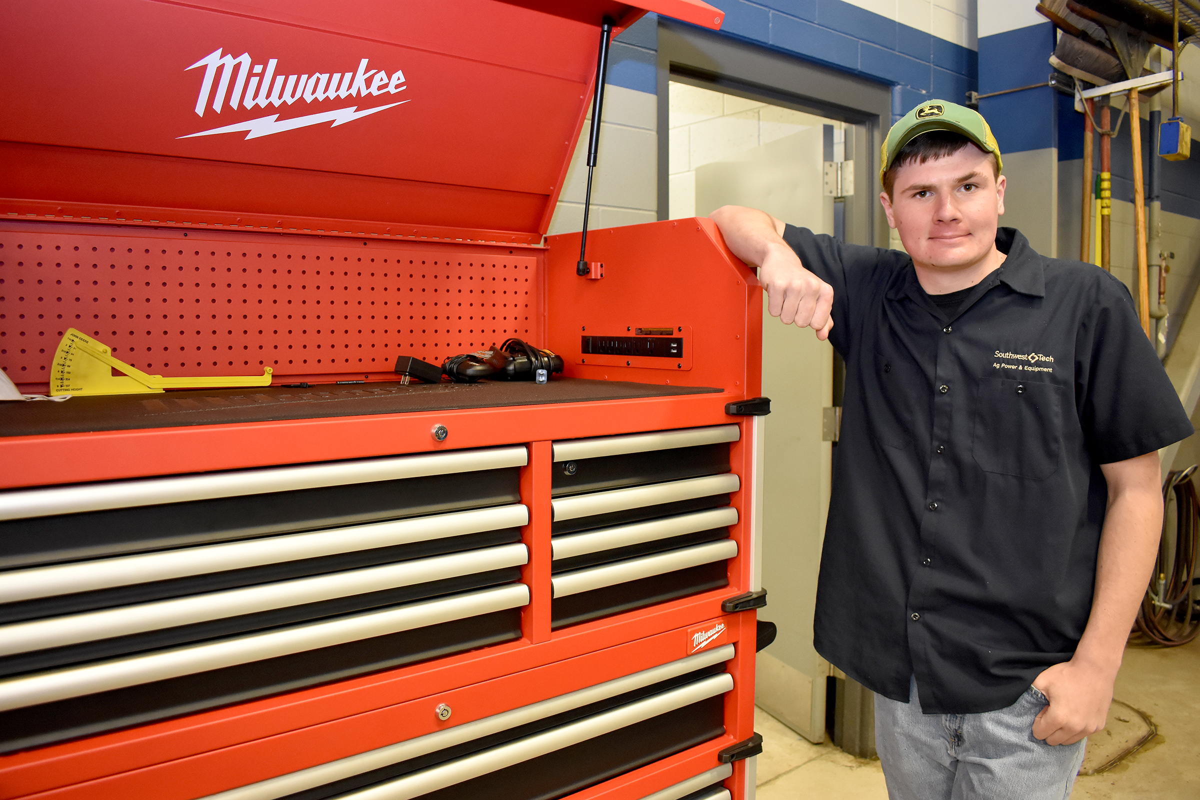 Male student standing next to open large toolbox.