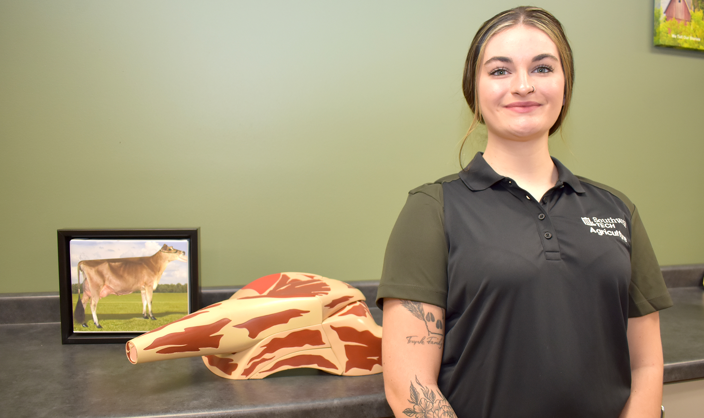 Female student standing next to model of meat cuts.