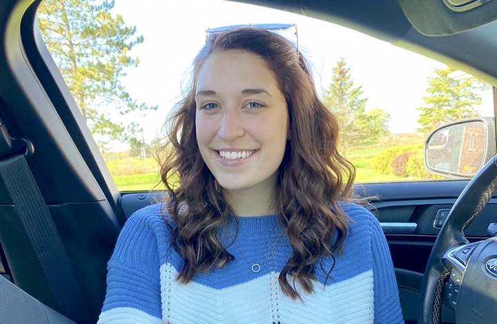 Female student smiling. Blue and white sweater.