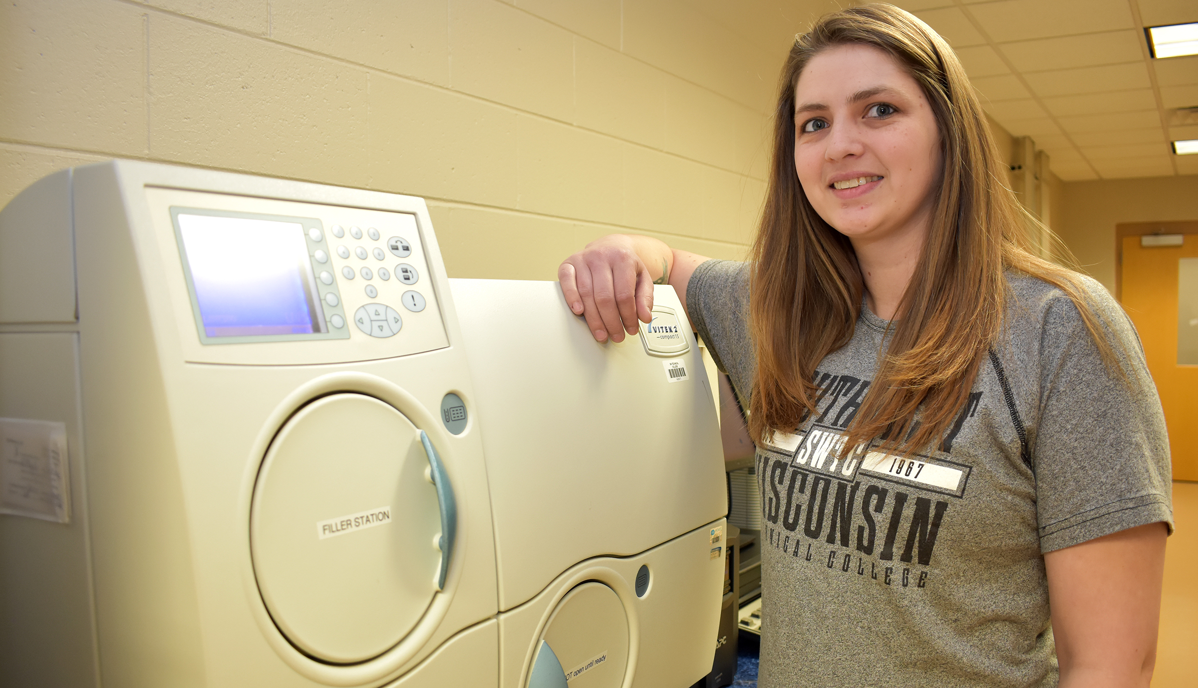 Female student standing next to medical lab equipment.