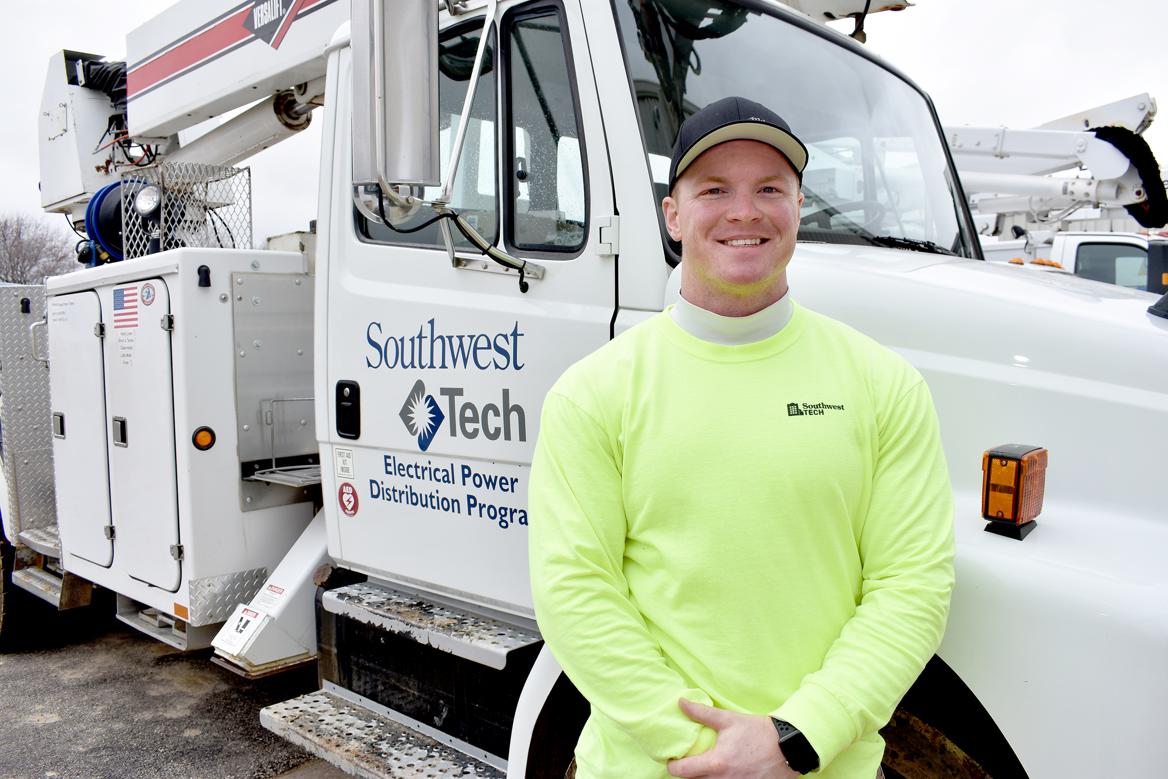 Male student in bright neon shirt in front of electric utility shirt.