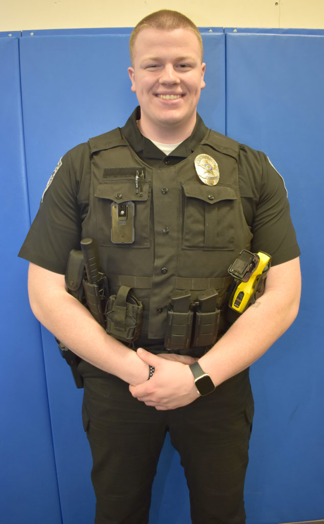 Male student standing, wearing police uniform.